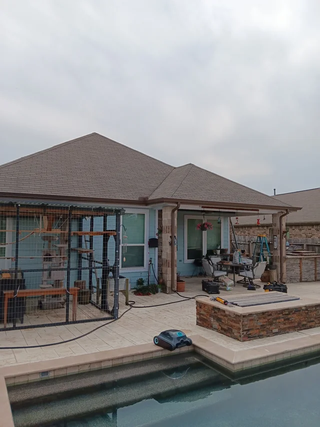 Gutter and downspout routing around a covered outdoor living area