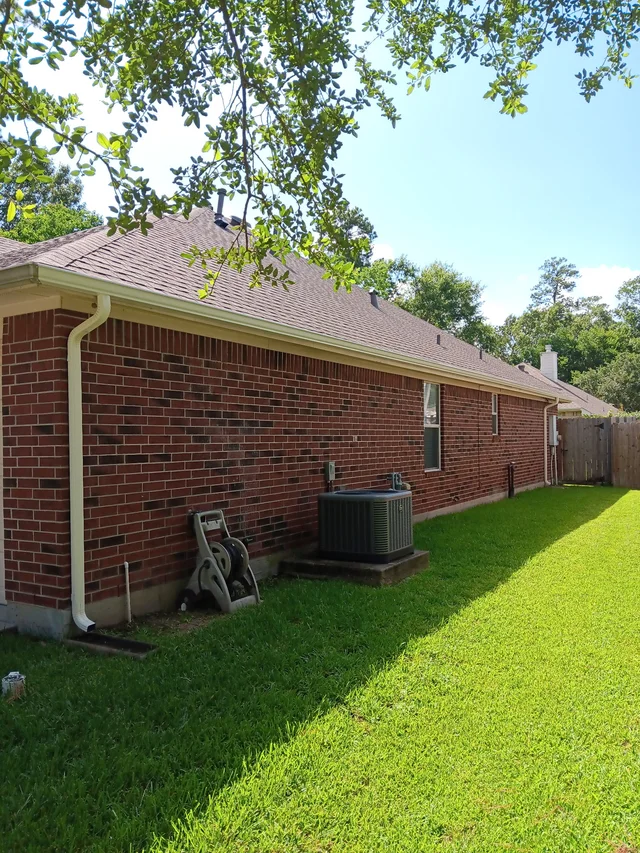 Gutters tracing the roof edge beside an enclosed yard
