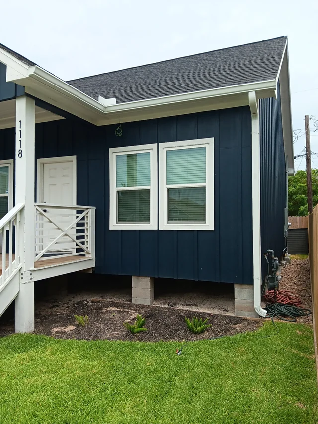 White gutters and downspouts against blue-gray siding