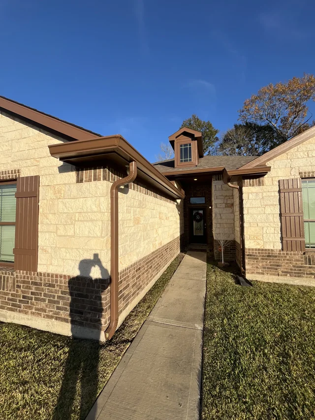 Dark roofline trim above a single-story brick home
