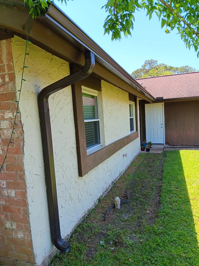 Gutter and downspout routing around a covered outdoor living area