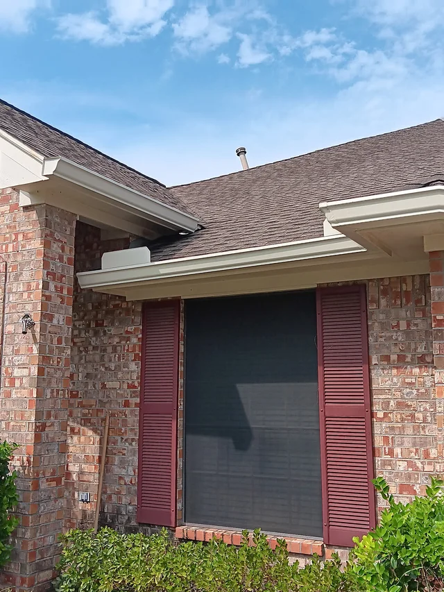 Dark gutters and downspouts around a brick exterior
