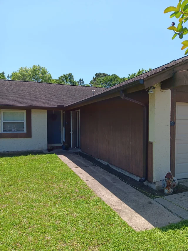 Gutter and downspout routing around a covered outdoor living area