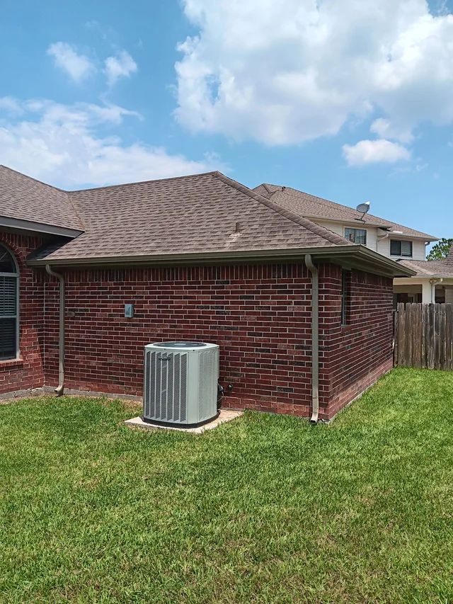 Gutters tracing the roof edge beside an enclosed yard